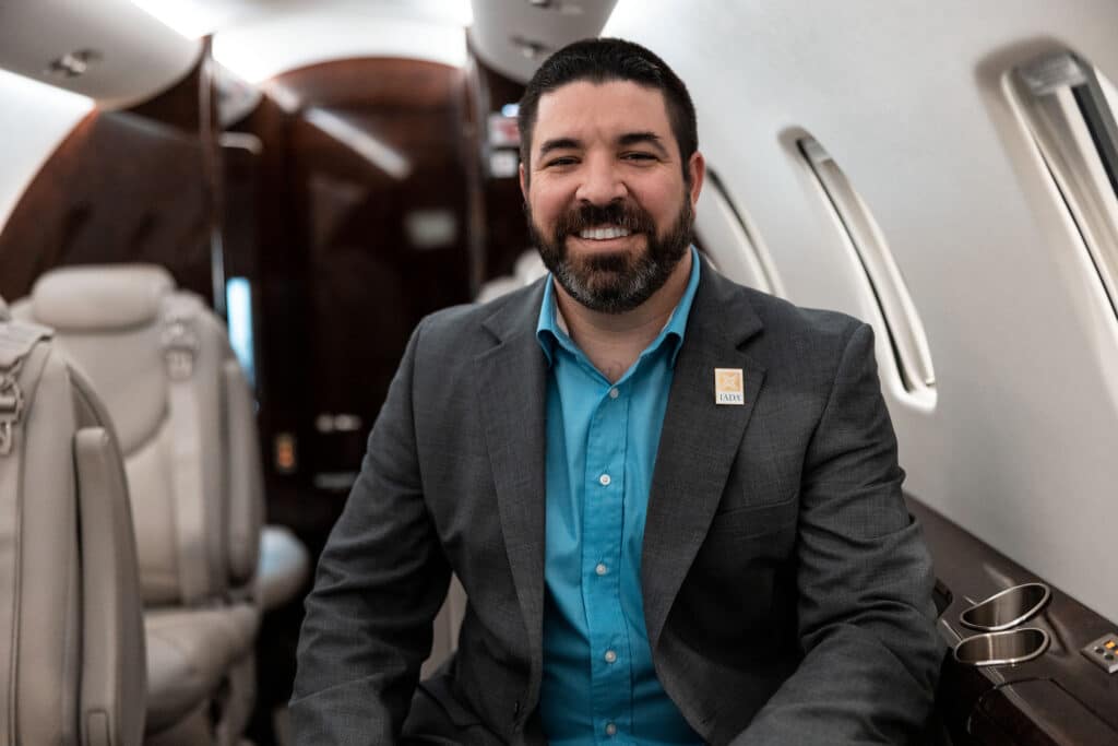 Michael Barber - Salesman of the year, 2023 Leviate Jet Sales inside a business jet smiling.