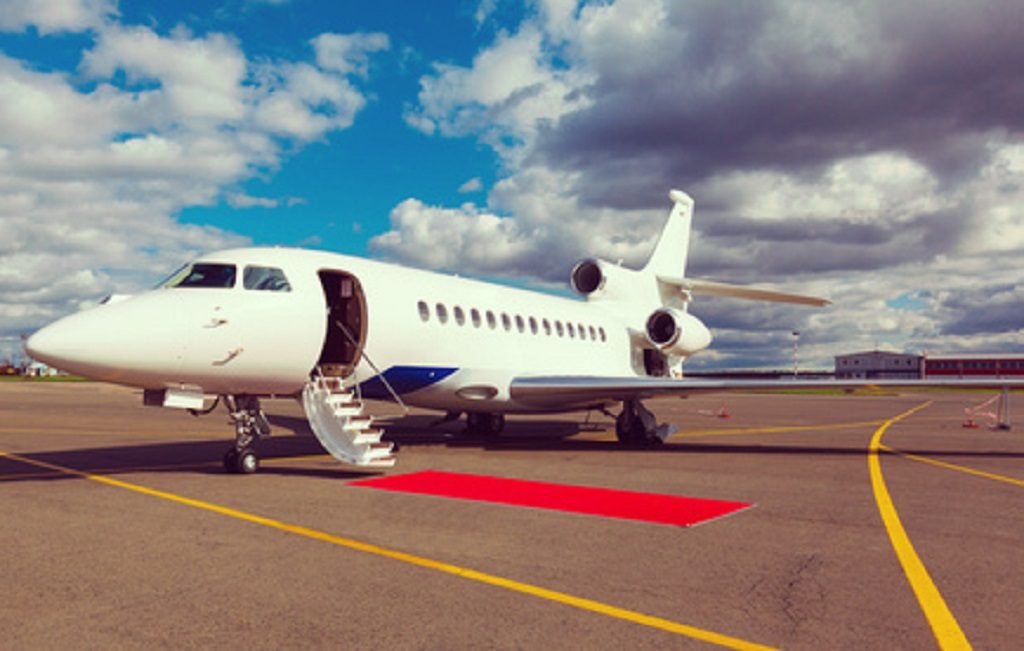 aircraft outside with red carpet in front of stairs