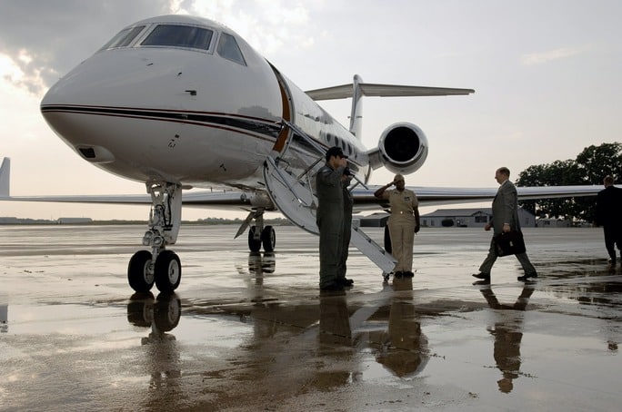 men boarding aircraft in rainy weather