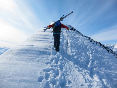person hiking mountain in snow